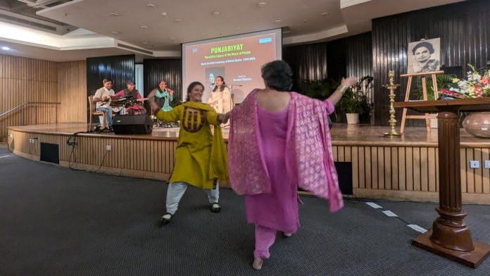 दिल्लीतील 'पंजाबियत: पंजाबच्या संगीताचा बहुसंख्यक वारसा' येथे सुनैनी शर्माने गायलेल्या लोकगीतावर दोन प्रेक्षक सदस्य उत्स्फूर्त नृत्य करताना.