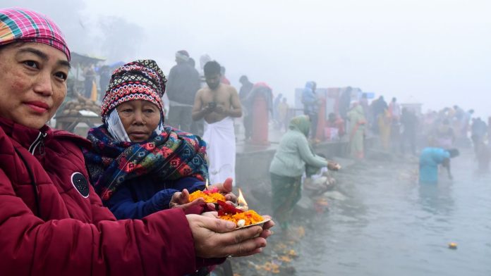 नर्मदा नदीच्या काठावर भाविक प्रार्थना करताना.