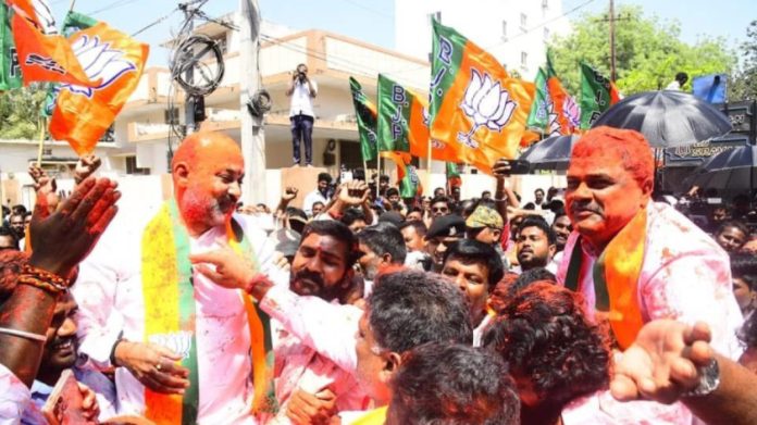 भाजपचे वरिष्ठ नेते बंदी संजय कुमार (डावीकडे) विजयी रॅलीत दोन एमएलसी विजेत्यांपैकी एक, मलका कोमरैया यांच्यासोबत आनंद साजरा करताना