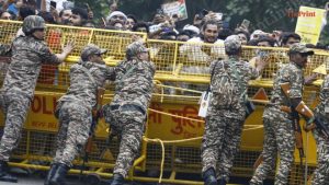 संसदेजवळील सुरक्षा बॅरिकेड्स तोडण्यापासून निदर्शकांना रोखण्याचा प्रयत्न करताना सुरक्षा कर्मचारी | प्रवीण जैन | द प्रिंट 